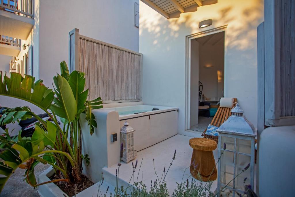 a bathroom with a tub in a room with plants at Fino Amore Private Jacuzzi Suite in Mykonos Town in Mikonos