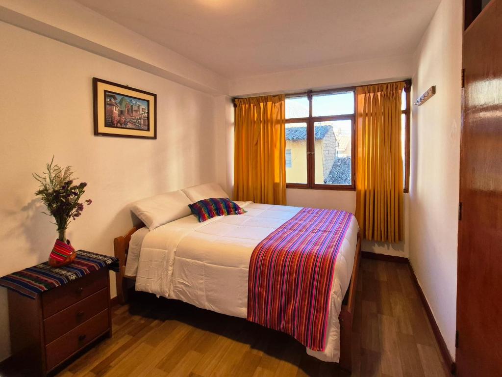 a bedroom with a bed and a window at VittoriaHouse in Ollantaytambo