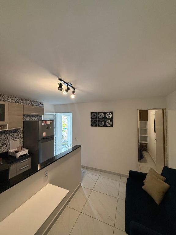 a living room with a couch and a kitchen at Cantinho Aconchegante - Apartamento Completo in Bayeux