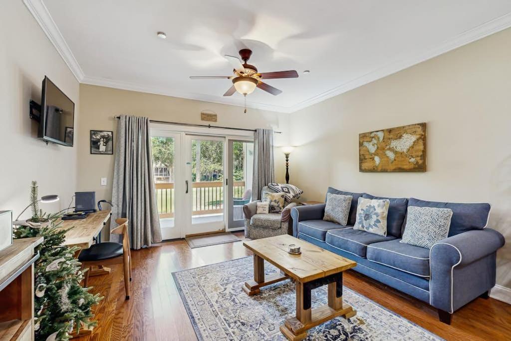 a living room with a blue couch and a ceiling fan at The Tidey Turtle in Edisto Beach