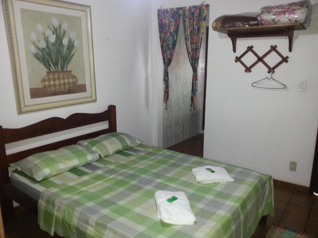 a bedroom with a bed with two towels on it at Itaúna Hostel in Saquarema