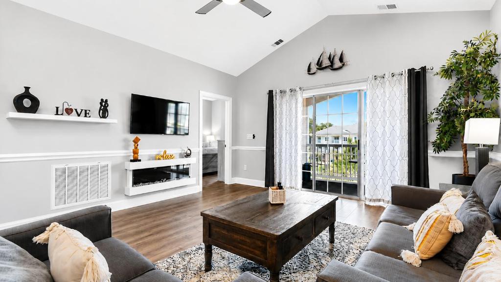 a living room with a couch and a table at Pet-Friendly Luxury 3BR with Pool Sleeps 8 Near Beach in Myrtle Beach
