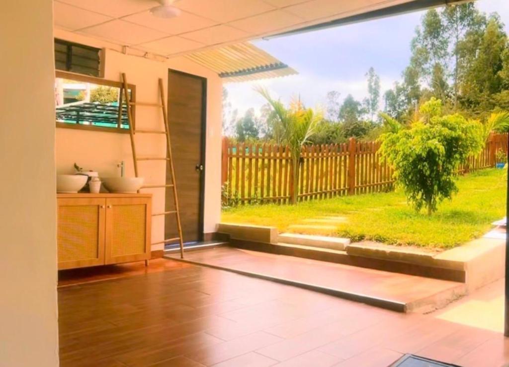 a room with a large window with a garden outside at villa paraíso in Piura