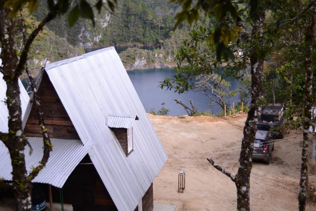 ein Haus mit einem weißen Dach neben einem See in der Unterkunft Cabañas Cinco Lagos in Santiago
