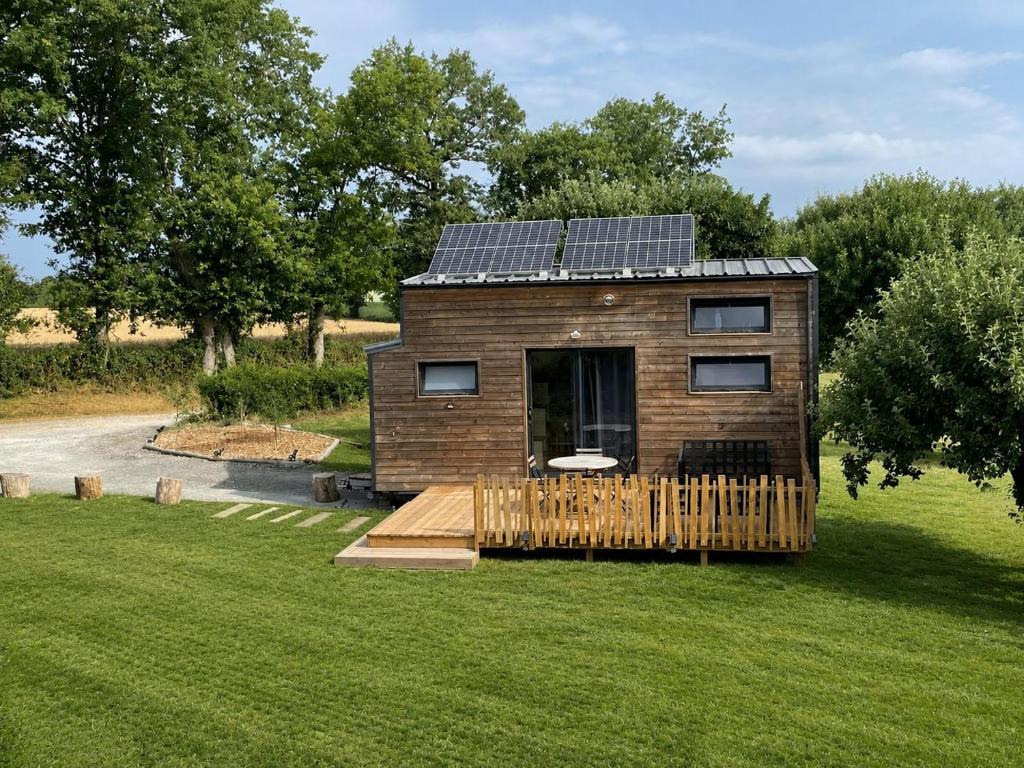 a tiny house with solar panels on its roof at La Tiny des Prés in LʼAbsie