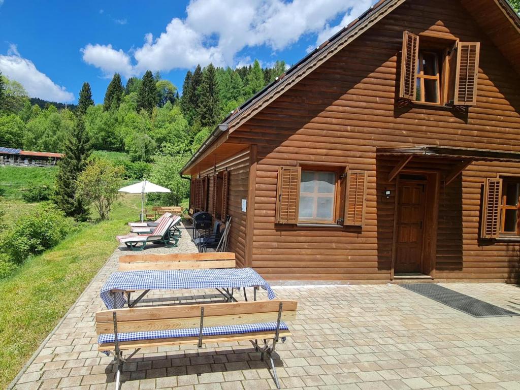 a wooden cabin with benches and a table in front of it at Sternenchalet in Liebenfels