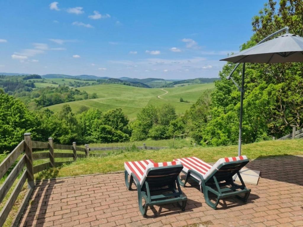 two picnic tables and an umbrella on a brick patio at Karawankenpanorama in Liebenfels