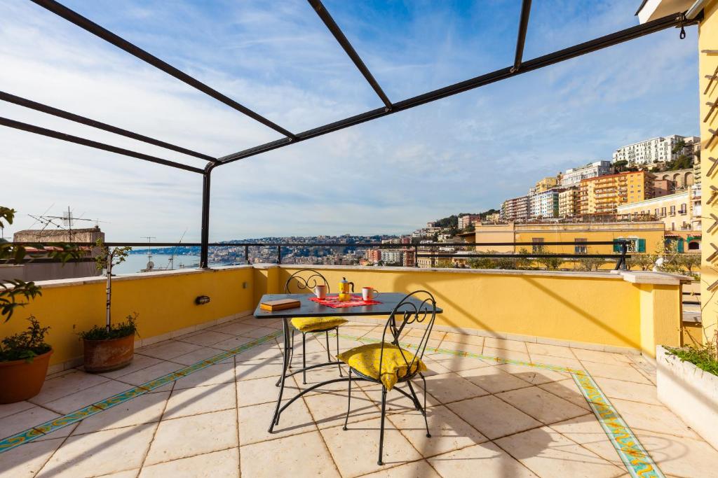 ナポリにあるBright Rooftop by Napoliapartmentsの市街の景色を望むバルコニー(テーブル、椅子付)