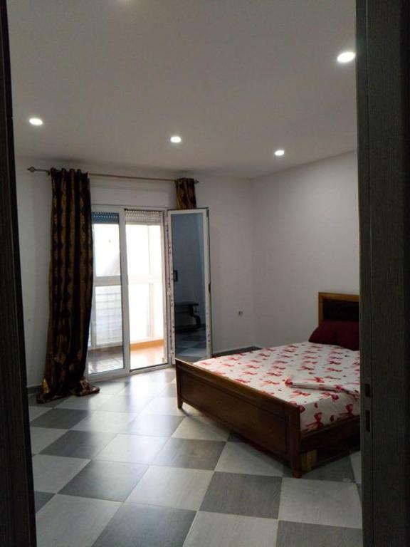 a bedroom with a bed and a large window at Anis in Annaba