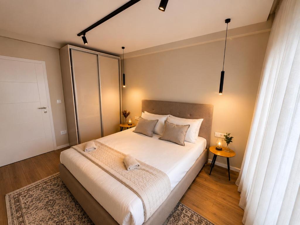 a bedroom with a large white bed with two pillows at Vi Lux Apartments in Visoko