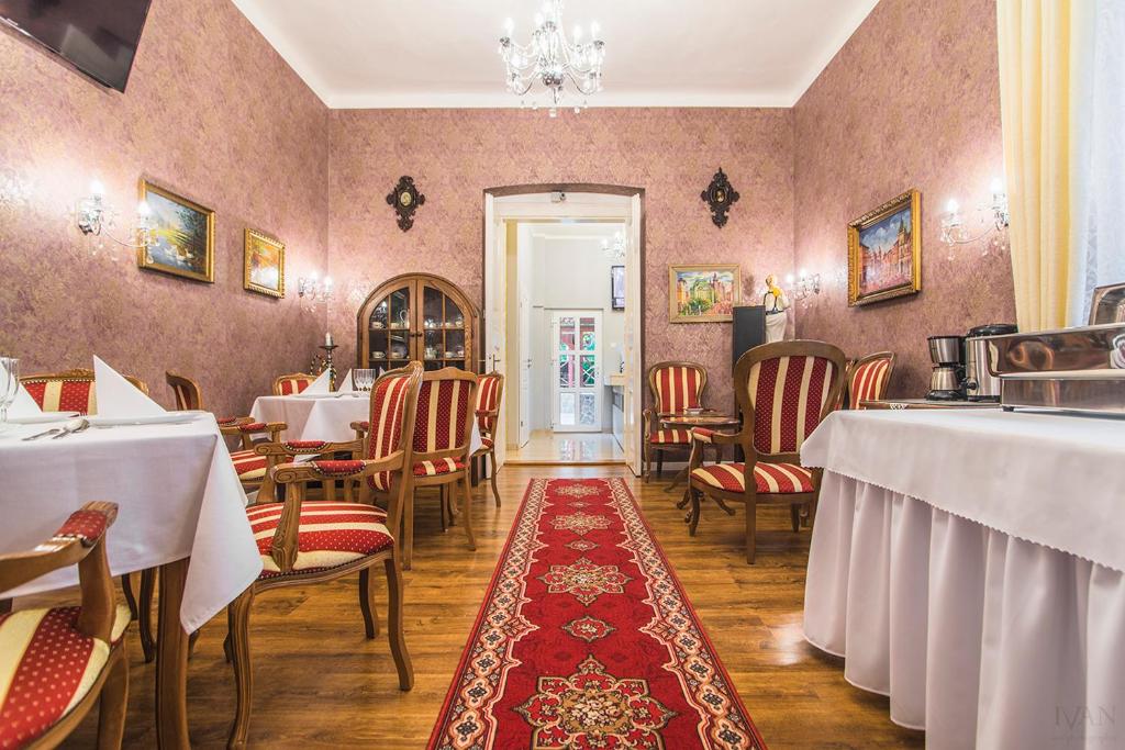 un restaurante con mesas y sillas y una alfombra roja en CenterCity Apartments, en Prešov