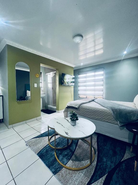 a bedroom with a bed and a table in it at Sunset guest house in Soweto