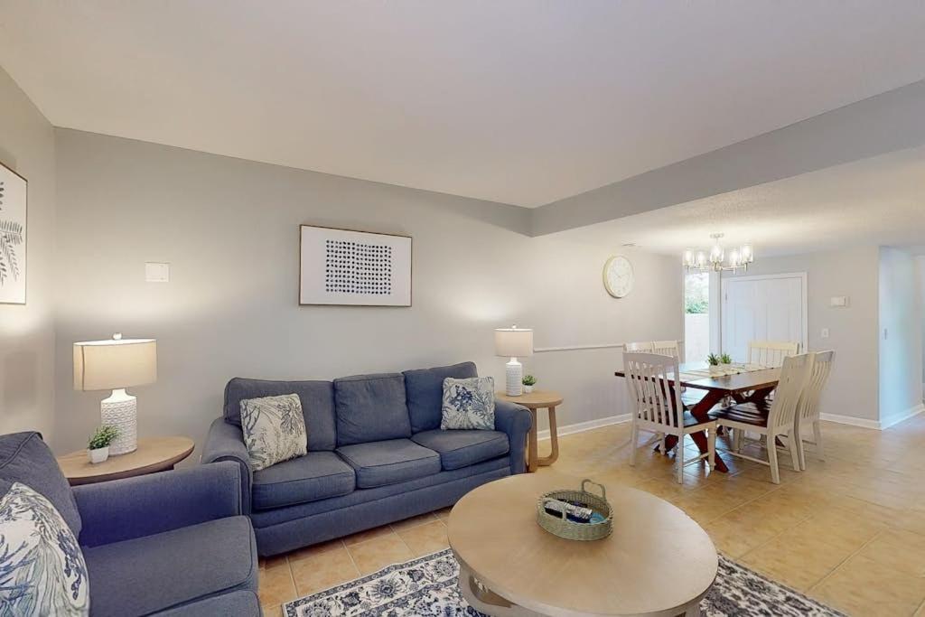 a living room with a blue couch and a table at Beach Club Bungalow in Hilton Head Island