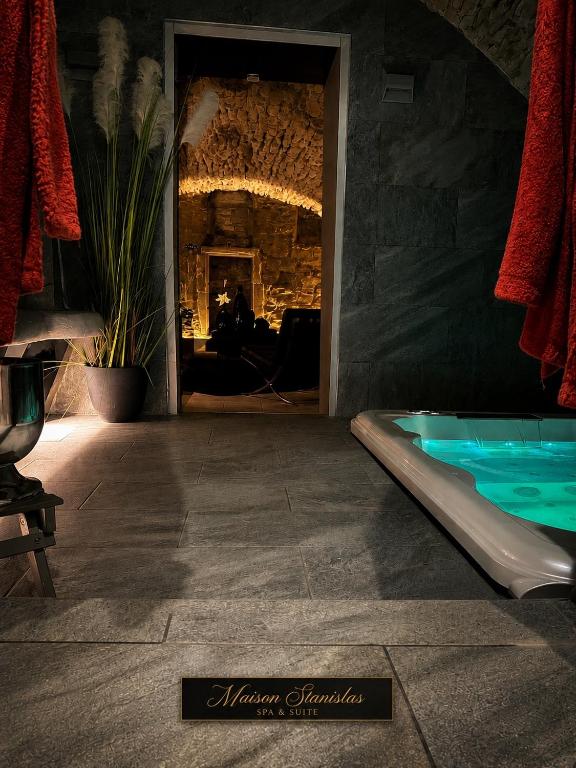 a swimming pool in a room with a fireplace at Maison Stanislas Spa Suites in Nancy