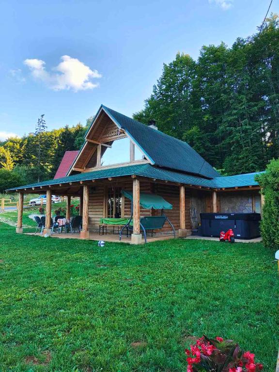 a log cabin with a pitched roof on a yard at Vila Maja in Rudno