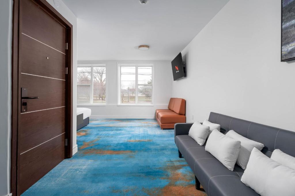 ein Wohnzimmer mit einer Couch und einer Tür in der Unterkunft Plush Hotel Downtown Toronto in Toronto
