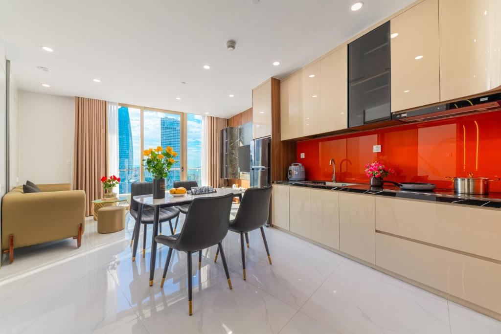 a kitchen with red cabinets and a table and chairs at PinkyRiver in Danang