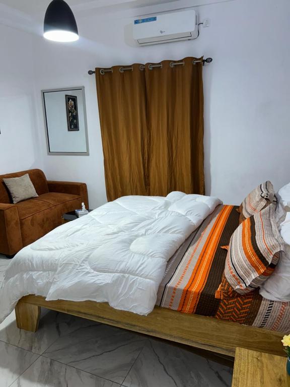 a bedroom with a large bed with a curtain at Résidence Eden2 in San-Pédro