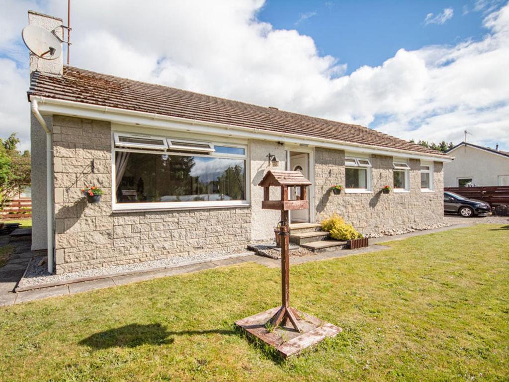 a home with a bird house in the yard at Caledon in Aviemore