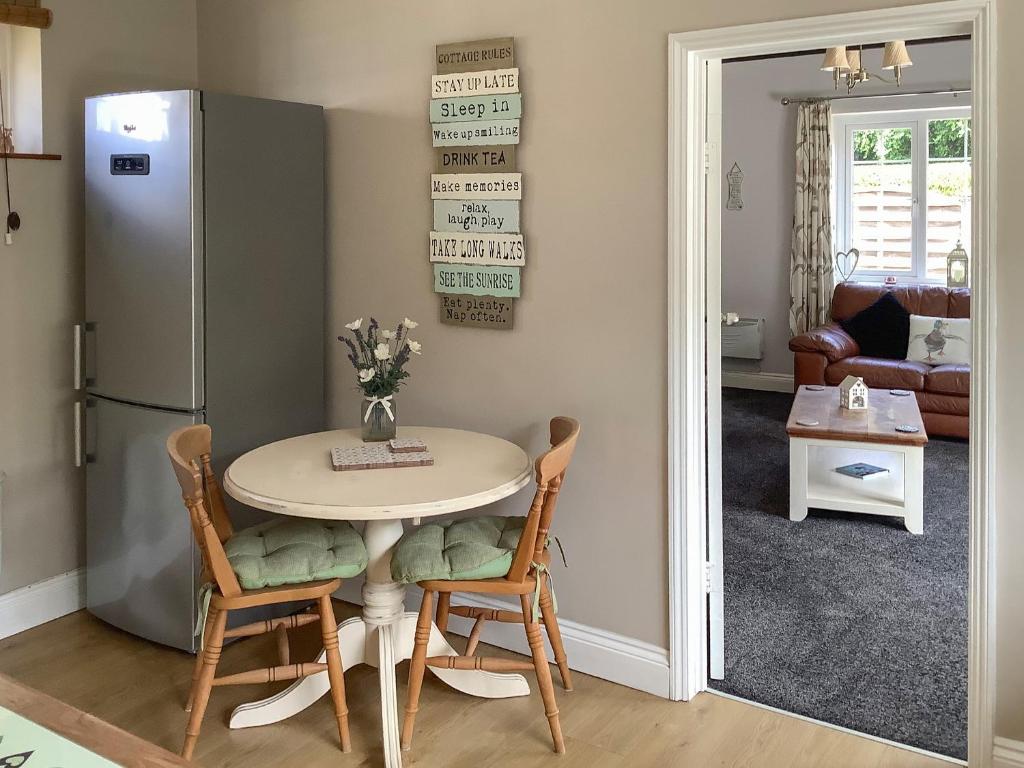 a kitchen with a table and a refrigerator at Clinton Cottage in Yaxham
