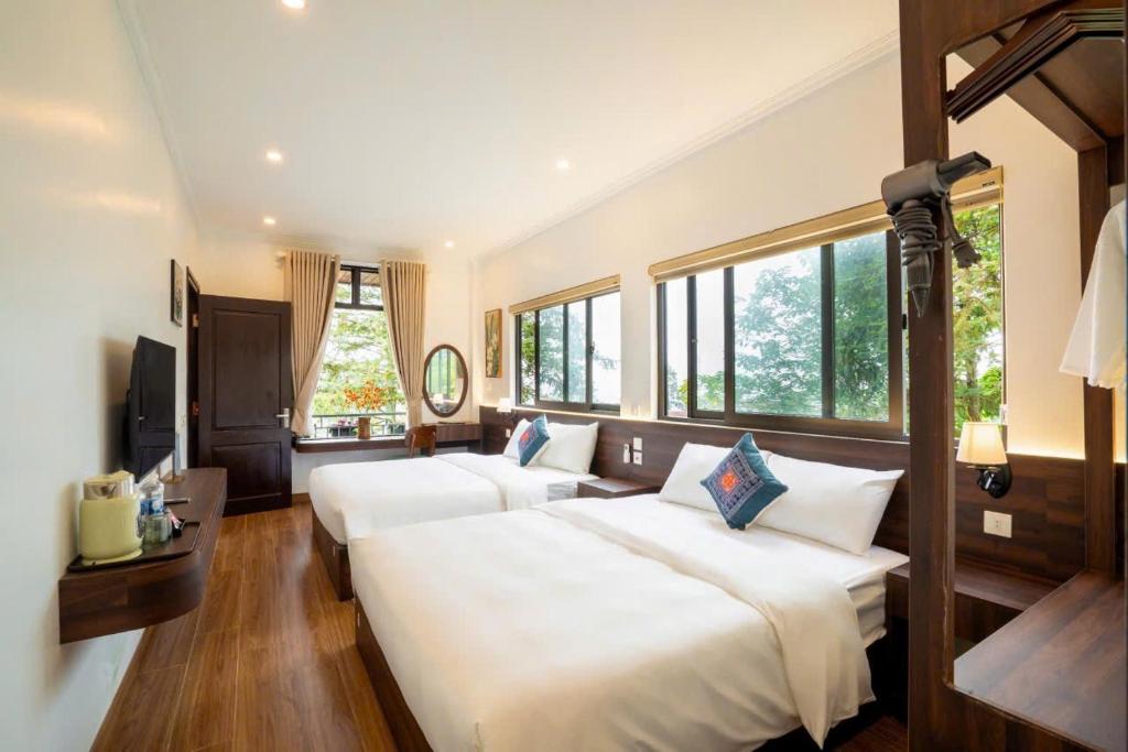 a large bedroom with two beds and windows at Pine Hill Villa Sapa in Sapa