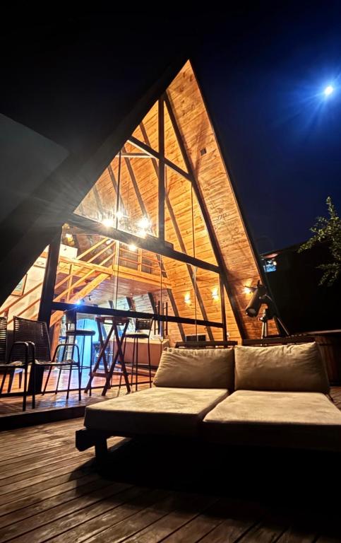 a living room with a couch on a deck at Lakefront Chalet, hot tub, heated bathtub and waterfall in Alexânia