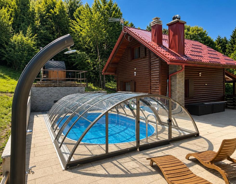 a pool with a glass dome next to a house at Kuća za odmor Cozy Bear Cabin in Brestova Draga