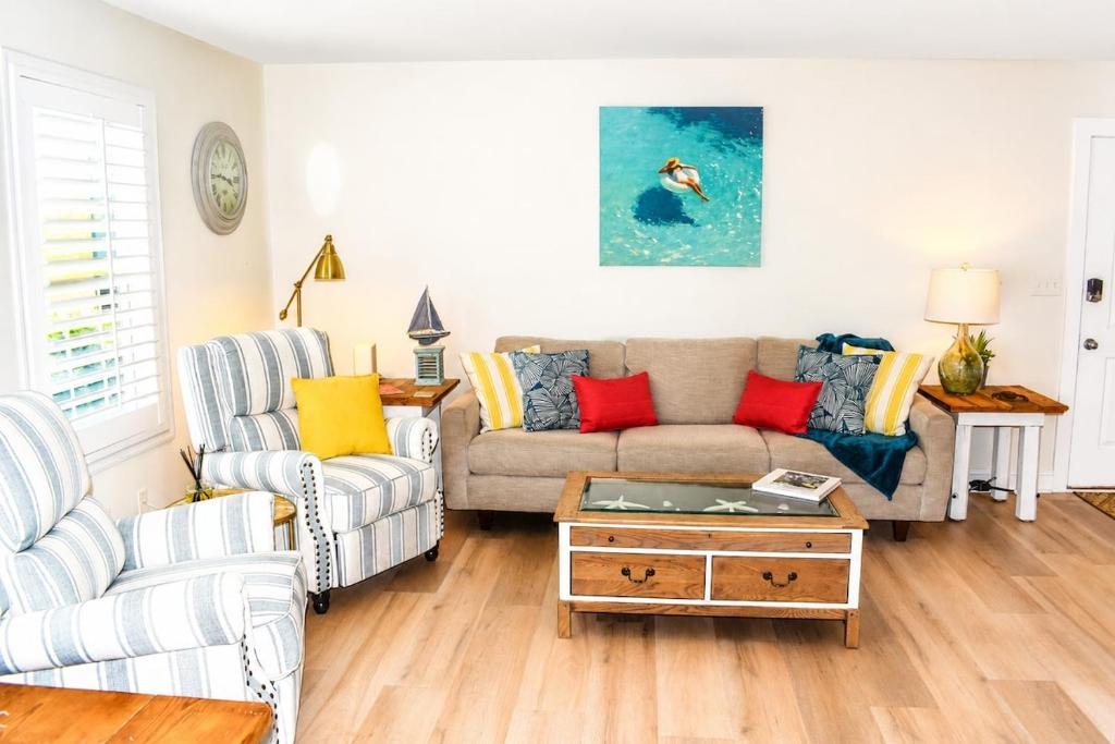 a living room with a couch and a table at Bright Coastal Condo in Saint Simons Island