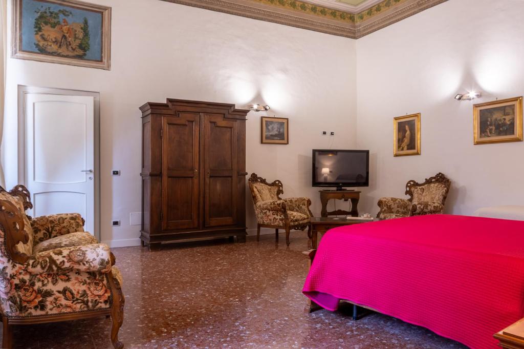 a bedroom with a red bed and a tv at B&B del pozzo in Narni