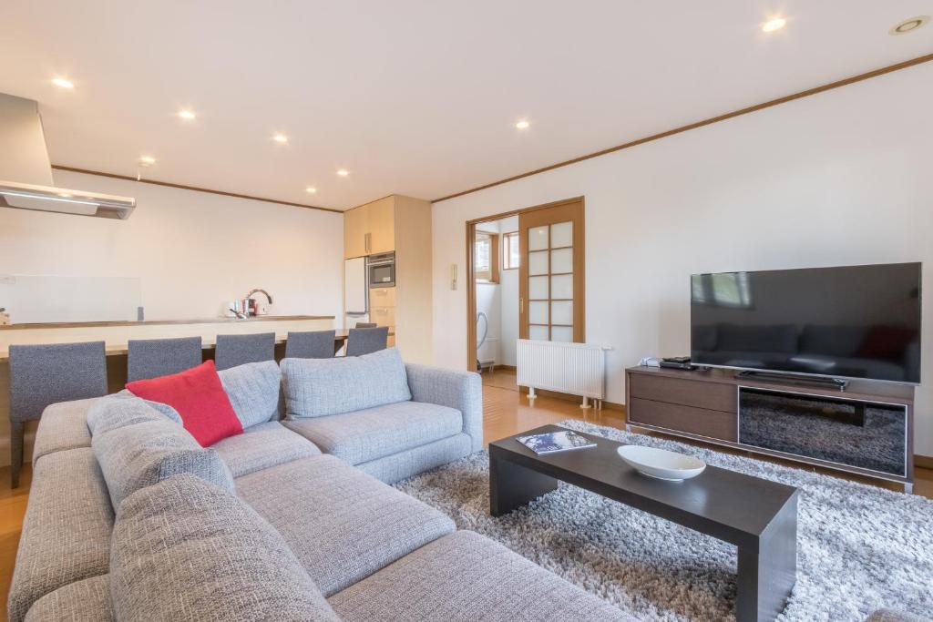 a living room with a couch and a tv at Kiseki in Kutchan