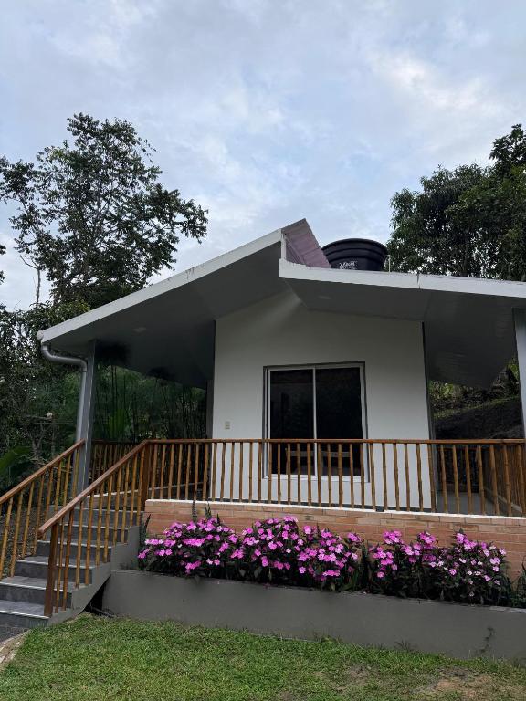 a small house with purple flowers in front of it at Morada Silvestre in La Peña
