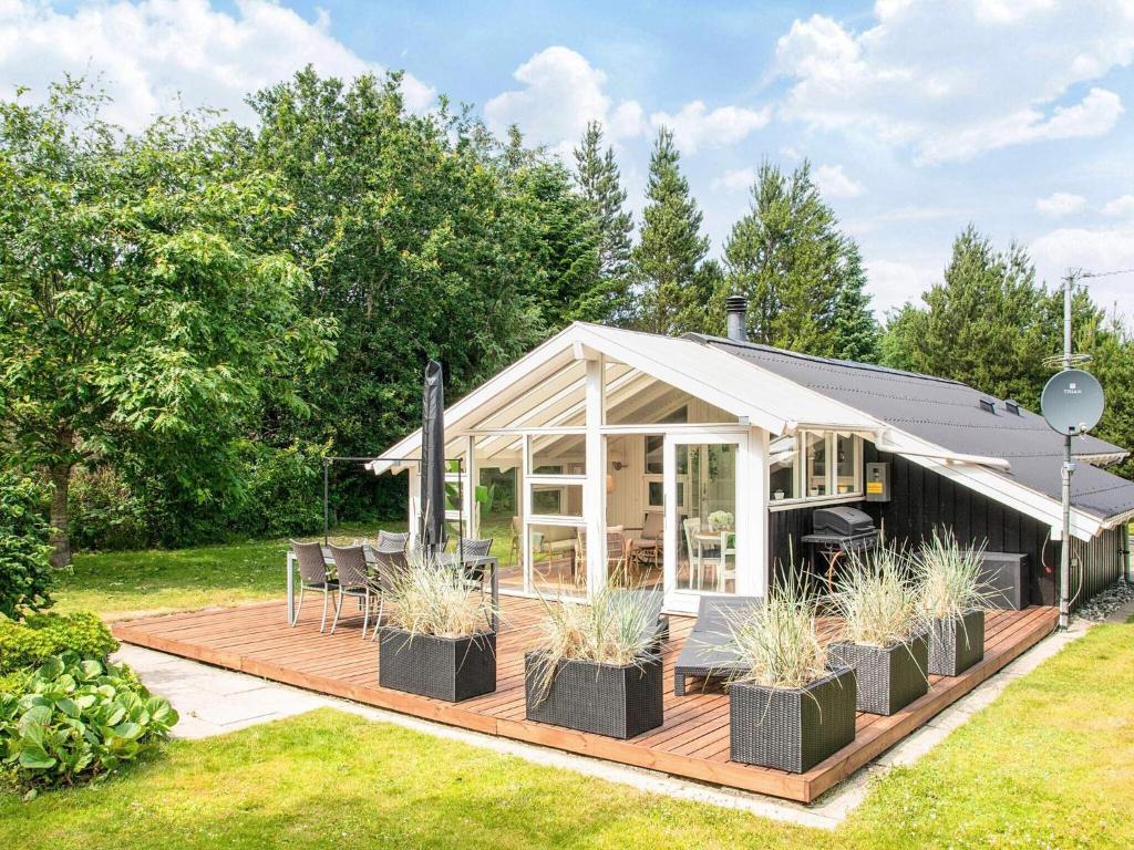 a house with a deck with plants in the yard at 6 person holiday home in Ulfborg in Ulfborg