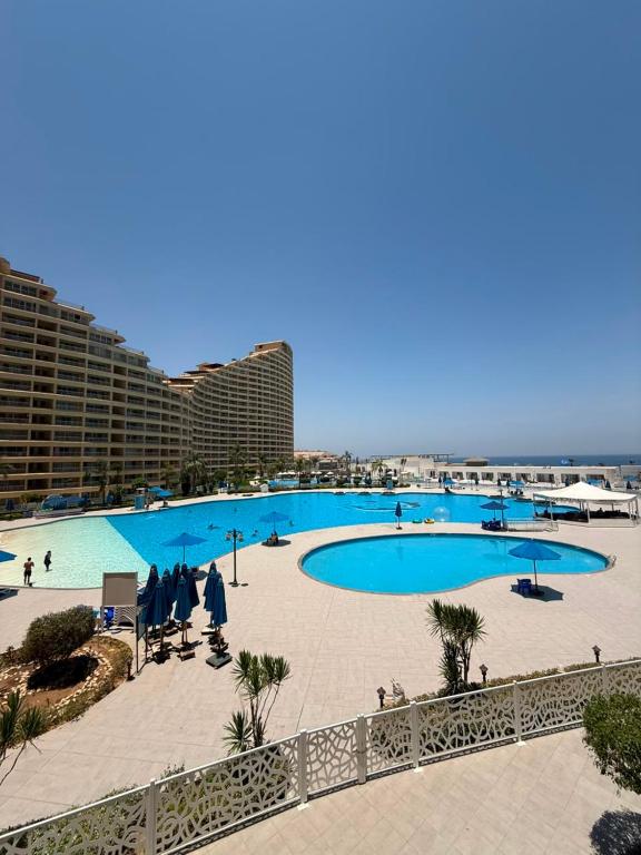 a large swimming pool next to a beach with buildings at Porto Sokhna Aprtment Pool View - MR in Ain Sokhna