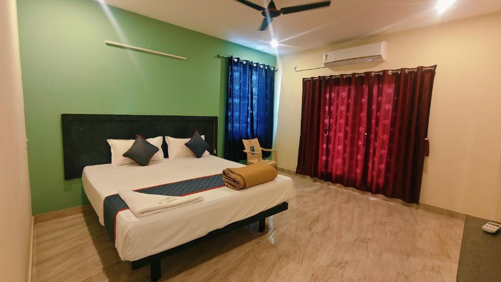 a bedroom with a bed in a room with green walls at Melody Stays Inn in Chennai