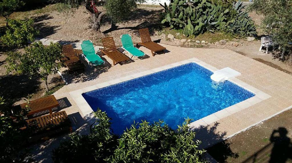 einen Blick über einen Pool mit Stühlen und einem Pool in der Unterkunft Villa Kaloudis in Kolymbia