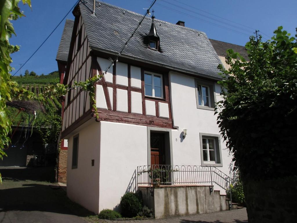 een oud wit huis met een zwart dak bij Historisches Ferienhaus Abteistraße in Mesenich
