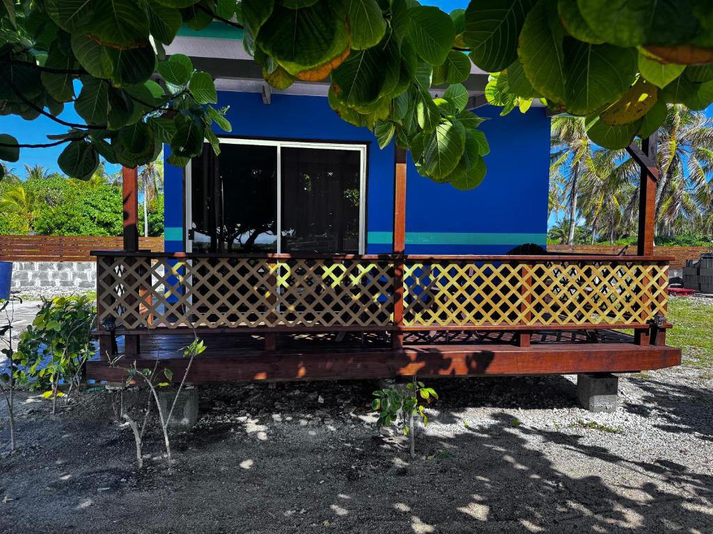 a bench in front of a blue house at Dream lodge in Rangiroa