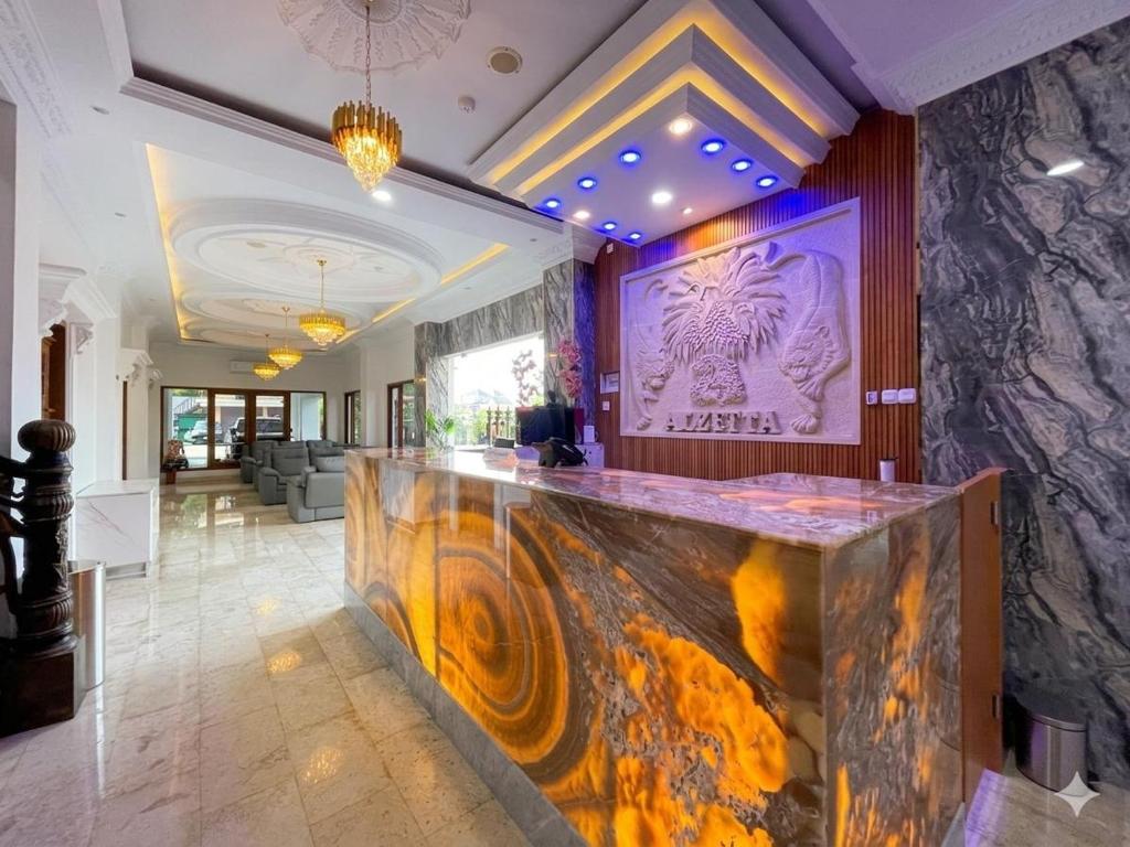 a lobby with a bar with a painting on the wall at Alzetta Hotel by Abiza in Timuran