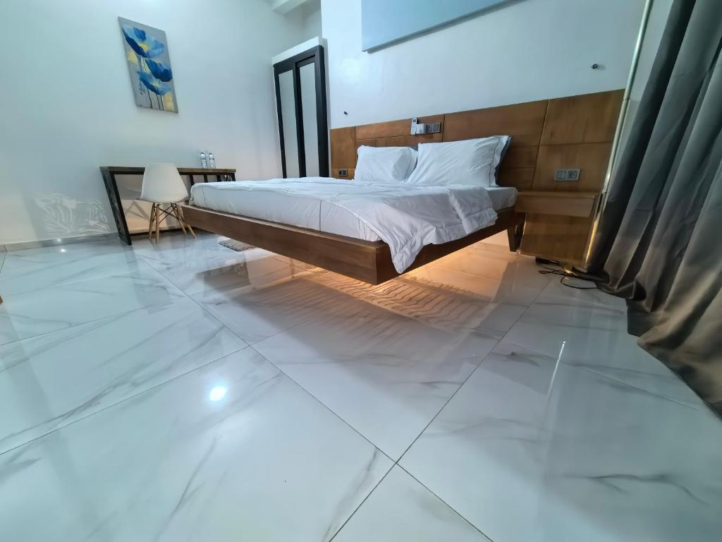 a bedroom with a bed and a tiled floor at OLA LUXURY HOTEL Parakou in Parakou