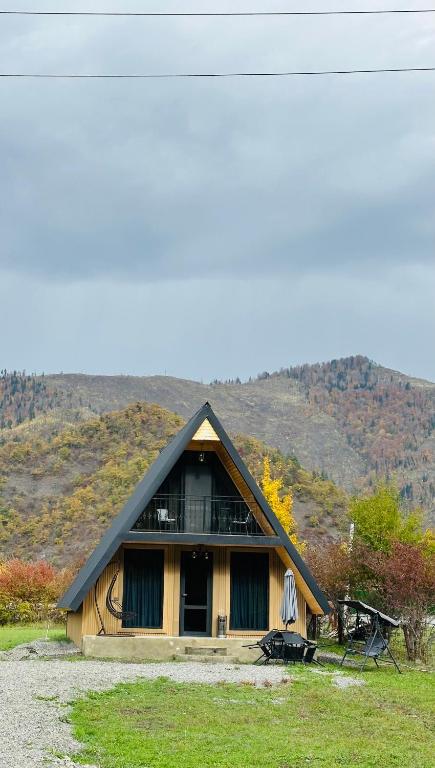 a house with a thatched roof on a field at Hiyadel balcony in Sadgeri