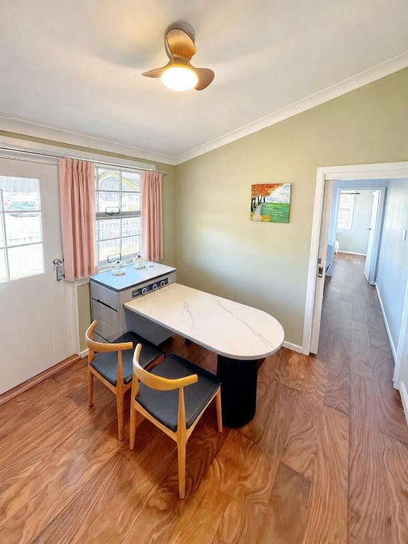 a kitchen with a table and two chairs in a room at Coffs Coastal Cabin, Central & Convenient in Coffs Harbour