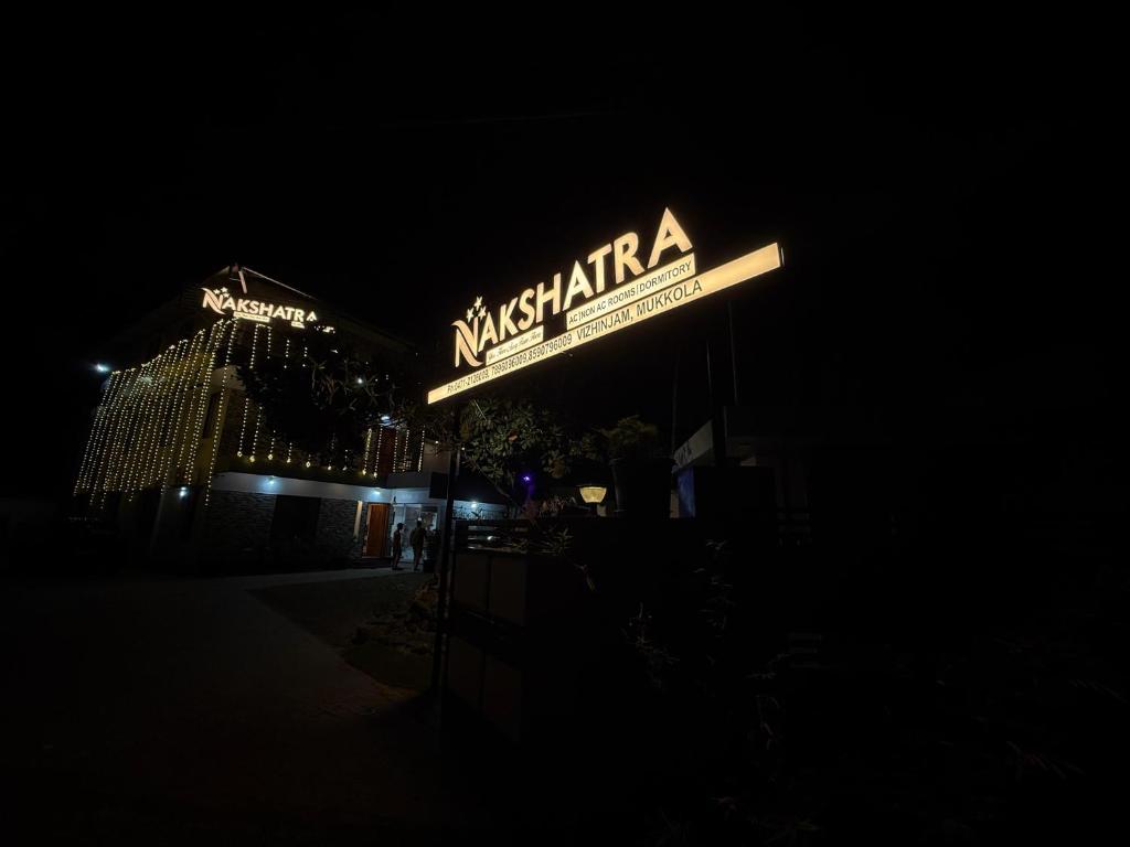 a neon sign for a restaurant at night at Nakshatra in Kovalam