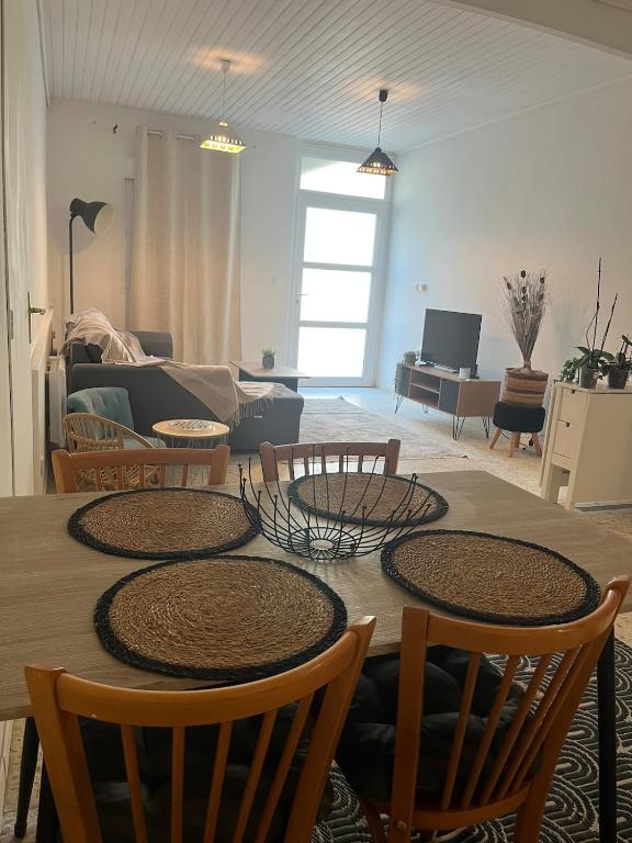 a living room with a table with chairs and a couch at Le Cocon d aurélie in Thèzan-lès-Béziers