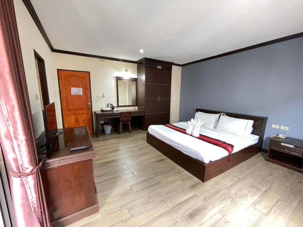 a bedroom with a bed and a desk and a television at Emporium Chiangmai in Chiang Mai