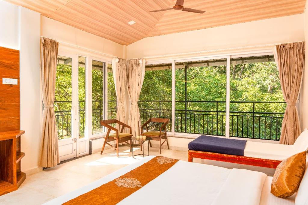 a bedroom with two beds and a large window at Green Nest Resorts in Malebennūr