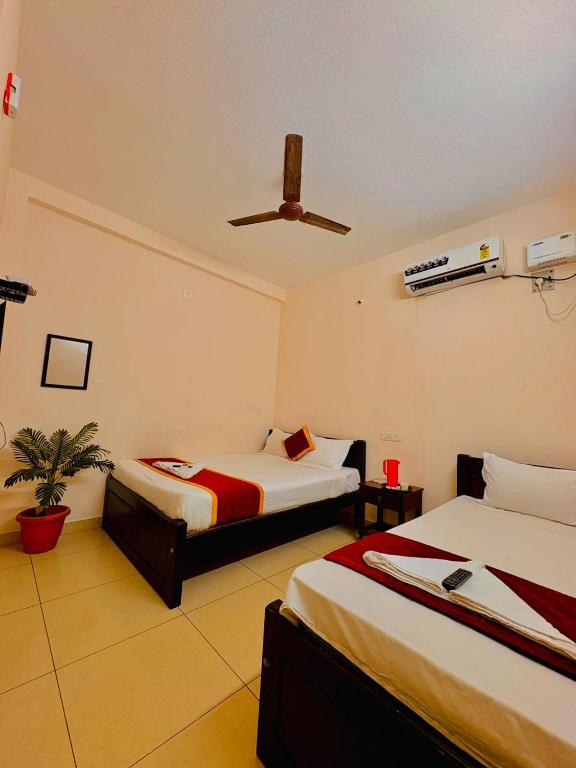 a bedroom with two beds and a ceiling fan at La town beach stay in Pondicherry