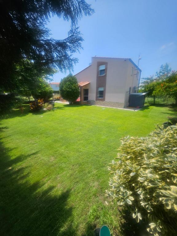a house in a yard with a green lawn at paralia ofriniou beautiful house in Karianí