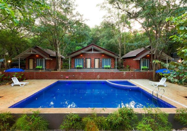 a house with a swimming pool in front of a house at Rain Forest Jungle Stay in Kurandi