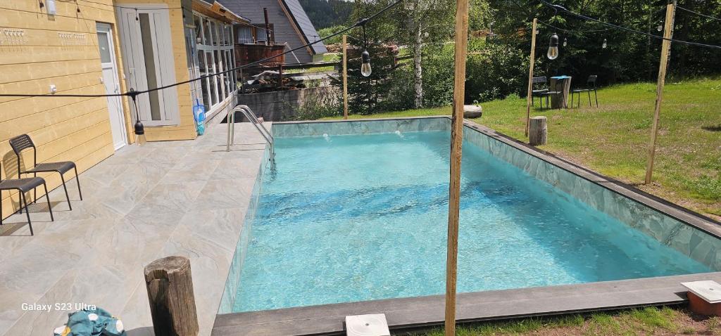 a swimming pool in the backyard of a house at Cabana din Vale Arieseni Apuseni cu Piscina in Arieşeni