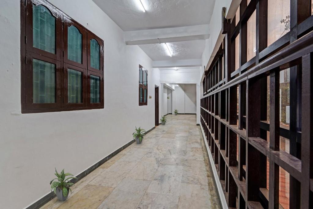 an empty hallway with plants in a building at Hotel O Grand Pallavaram in Chennai